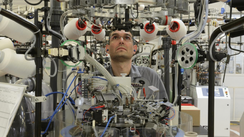 Homme qui est dans une usine à textile.