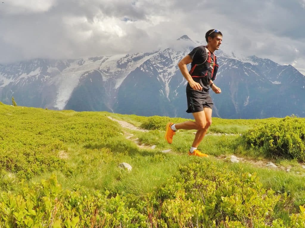 Coureur sur un sentier avec les montagnes en arrière-plan.