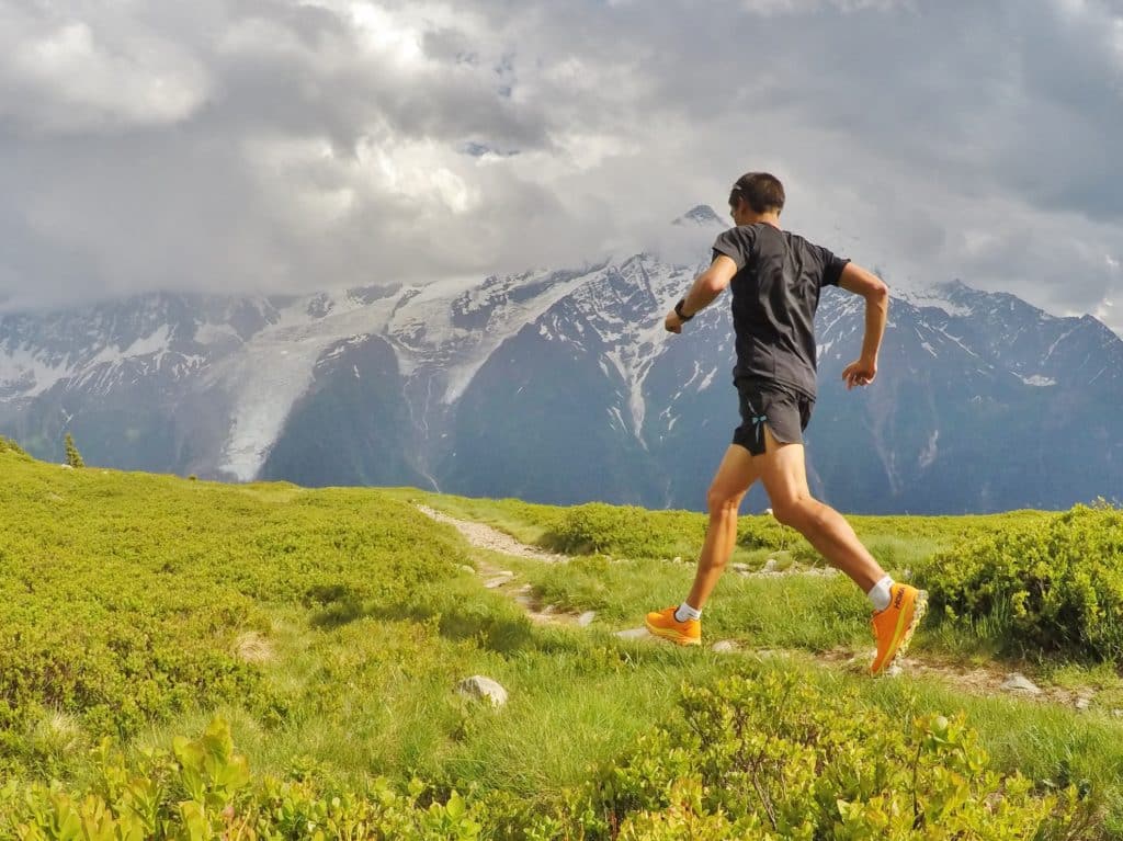 Homme qui court face aux montagnes.