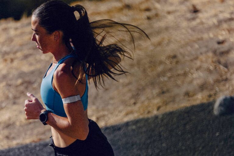 Coureuse utilisant une montre GPS et un capteur cardio Coros